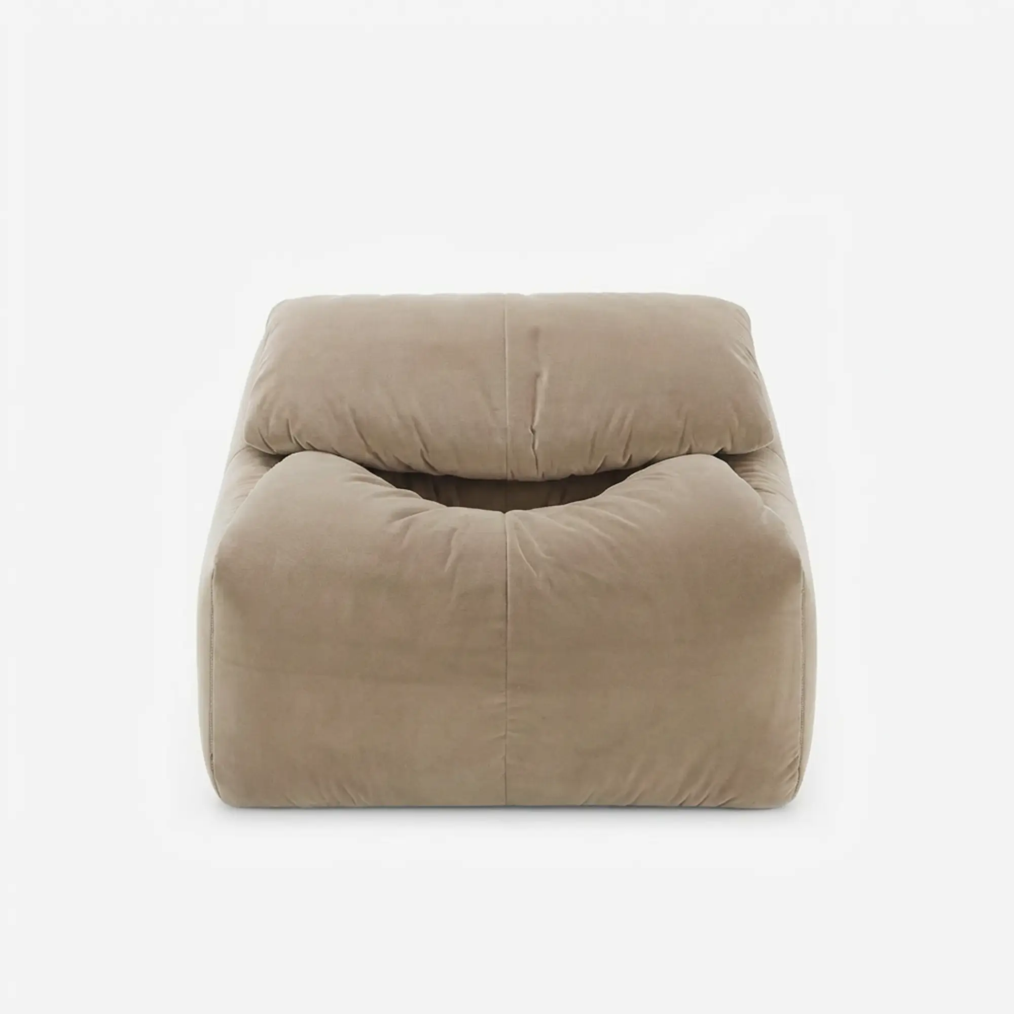 Beige plush armchair with a low back and soft, rounded cushions.